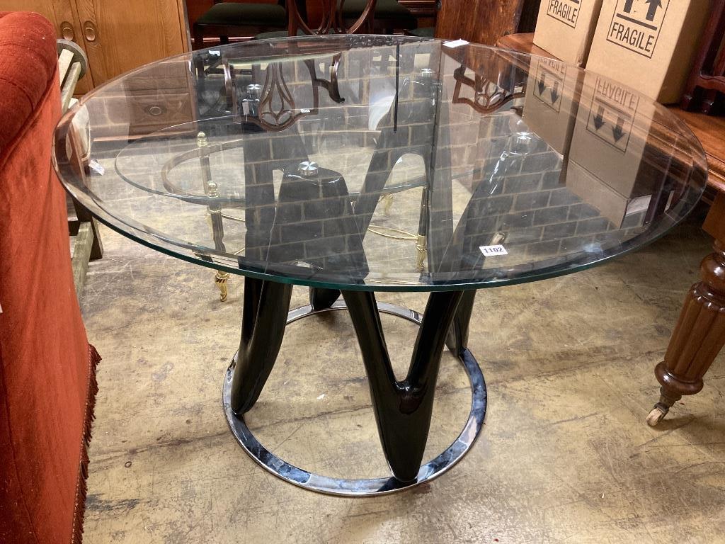 A contemporary circular glass top table, 120cm diameter, height 77cm